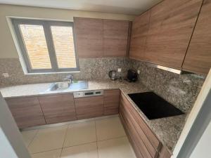 a kitchen with wooden cabinets and a sink and a window at Waterfront - B luxury in Dakar