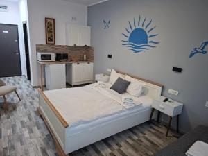 a bedroom with a bed and a kitchen at LA PLAYA - Studiouri pe plaja cu sezlong inclus in Eforie Nord
