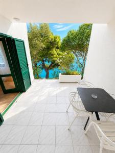 a patio with a table and chairs and trees at Povlja Bungalows in Povlja