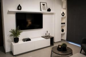 a living room with a large television on a wall at Minimal Panorama Loutraki in Loutraki