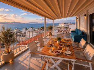 a table on a balcony with a view of the ocean at Minimal Panorama Loutraki in Loutraki