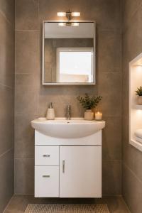 a bathroom with a white sink and a mirror at Minimal Panorama Loutraki in Loutraki +26 photos