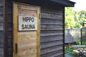 a door to a sauna with a sign on it at 古民家宿まるもり in Wada