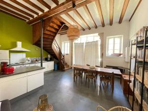 a kitchen and dining room with a table and chairs at La Canetterie in Dole
