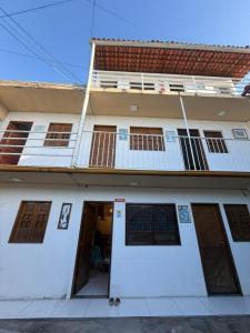 a white building with two floors and two doors at Condomínio Feitosa Barros II in Maceió