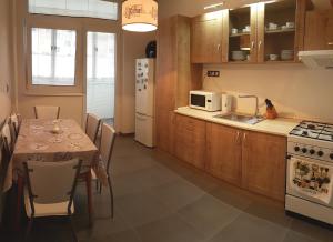 a kitchen with a table and a sink and a microwave at Apartman Anro in Kanianka