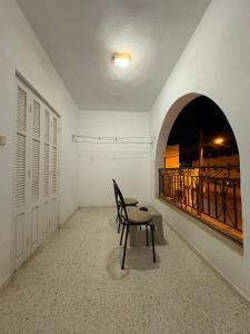a chair sitting in a room with a balcony at Dar KAMOUN - 2BR Apts with 5G WiFi & Parking, Houmt Souk & Corniche in Houmt Souk