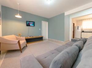 a living room with a large couch and a tv at Apartamento amplo e confortável 1 in Maringá