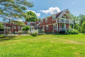 a large red brick house with a yard at The Landgrove in North Landgrove