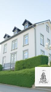 a white building with a sign in front of it at ESER Hotel Pension in Beuggen