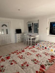 a bedroom with a large bed and a table with chairs at Apartmani Kruče in Ulcinj