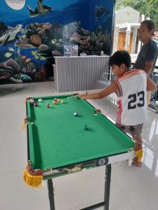 a man and a young boy playing pool at Sebastian Guest House in Moalboal