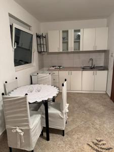 a kitchen with a table and chairs and a sink at Apartmani Kruče in Ulcinj
