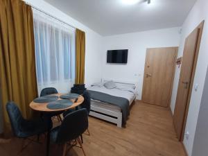 a bedroom with a bed and a table and chairs at Strumykowa 3 in Swornegacie