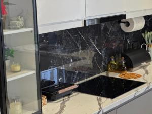 a kitchen with a black marble counter top at Villa Kalo in Blerimas +50 photos