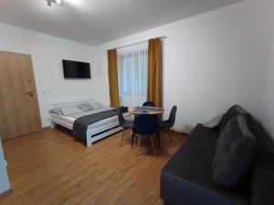 a bedroom with a bed and a table and a couch at Strumykowa 3 in Swornegacie