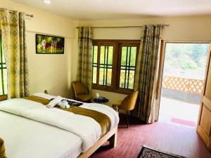 a bedroom with a bed and a large window at IBEX COTTAGE SHARDa in Shardi