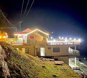 a house with a boat on a hill at night at IBEX COTTAGE SHARDa in Shardi