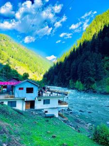 a bridge over a river next to a mountain at IBEX COTTAGE SHARDa in Shardi