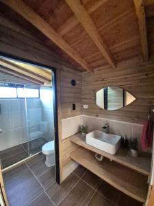 a bathroom with a sink and a toilet and a mirror at cabaña sol in Santa Elena