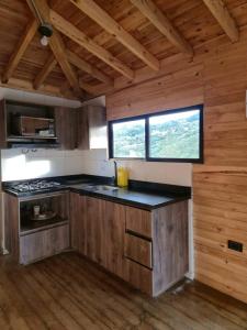 a kitchen with a stove and a window in a cabin at cabaña sol in Santa Elena