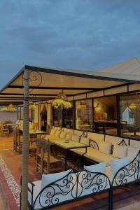 a pavilion with tables and chairs on a patio at Unique Luxury Camp in Merzouga