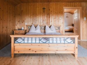 a bedroom with a bed with a wooden wall at Im Bayerischen Wald in Viechtach