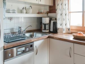 a kitchen with white cabinets and a sink at Im Bayerischen Wald in Viechtach +18 photos