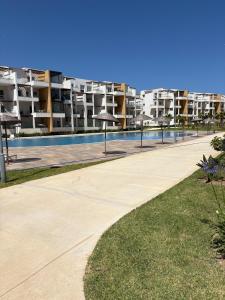 a swimming pool with an apartment building in the background at New Luxury apartment with 3 pool in Cabo Negro