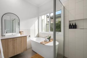 a bathroom with a tub and a sink and a window at 3BR Light-filled Retreat Mt Duneed in Mount Duneed
