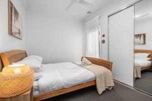 a bedroom with two beds and a mirror at 3BR Light-filled Retreat Mt Duneed in Mount Duneed +4 photos