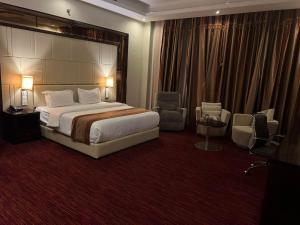 a hotel room with a bed and two chairs at فندق رفايا الشاطيء in Jazan