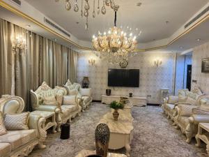a living room with white furniture and a television at فندق رفايا الشاطيء in Jazan