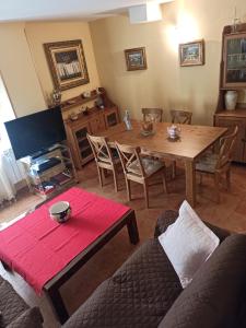 a living room with a wooden table and a couch at La Ribera del Río in Trefacio