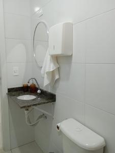 a white bathroom with a toilet and a sink at Recanto Tarobá in Ponta Grossa +14 photos