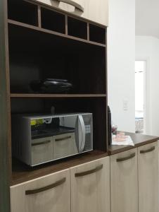 a microwave oven sitting on top of a cabinet at Recanto Tarobá in Ponta Grossa