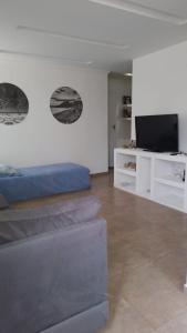 a living room with a blue couch and a tv at Yeshua - Casa da Claudia 8 in Ilha de Guaratiba
