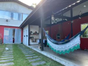 a hammock hanging from the side of a house at Yeshua - Casa da Claudia 8 in Ilha de Guaratiba