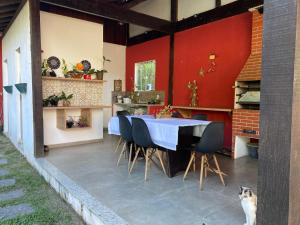 a kitchen and dining room with a table and a cat at Yeshua - Casa da Claudia 8 in Ilha de Guaratiba