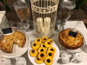a table topped with plates of donuts and a cake at Hotel Cinzia in Savignano sul Panaro