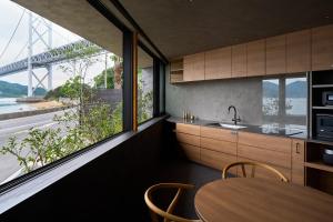 a kitchen with a table and a view of a bridge at Seaside Villa SEEN Shallow Sea in Onomichi