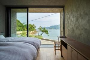 a bedroom with a large window with a view of the water at Seaside Villa SEEN Shallow Sea in Onomichi +34 photos