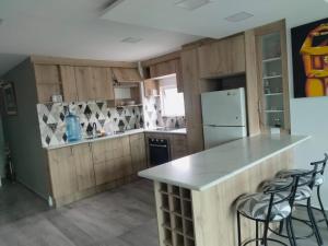 a kitchen with wooden cabinets and a counter with stools at HOSPEDAJE YACUCALLE in Ibarra