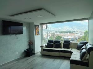 a living room with a couch and a large window at HOSPEDAJE YACUCALLE in Ibarra