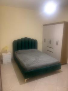 a green tufted bed in a room at Beautiful 2-bedroom apartment in Assomada