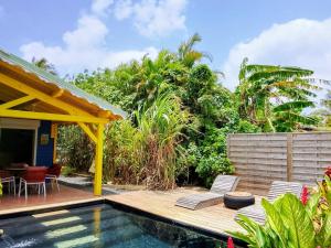 a villa with a swimming pool and a house at La Mare à Cuja in Sainte-Rose