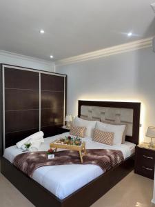 a bedroom with a large bed with a tray on it at APARTAMENTOS ALBATROS in Asilah