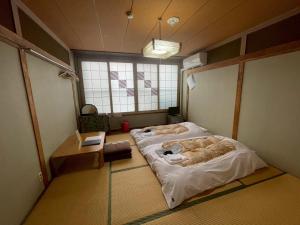 a room with two beds in it with a window at Uchihan in Nozawa Onsen
