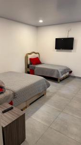 a room with two beds and a flat screen tv at House premium in Macanal