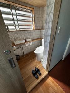 a bathroom with a toilet and a pair of shoes at Uchihan in Nozawa Onsen +32 photos